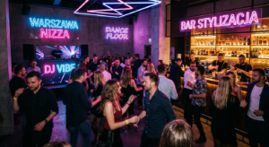 A high-end editorial photograph of a stylish, neon-lit Warsaw nightclub interior with blurred motion